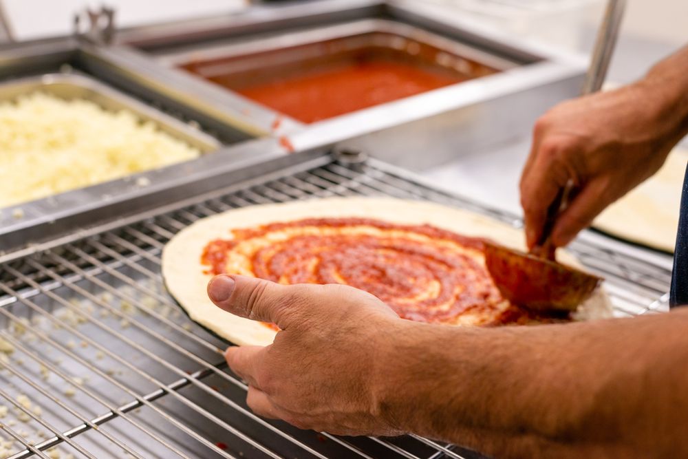 Spreading sauce on dough